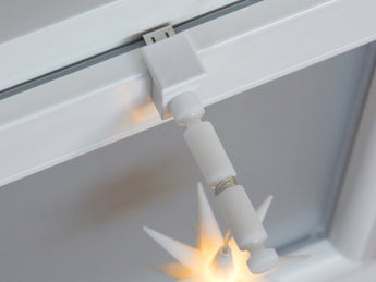 Weißer Fensterhaken mit Distanzhalter Größe L am Fenster mit leuchtendem Weihnachtsstern