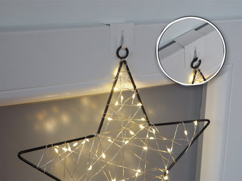 Weißer Metall-Fensterhaken mit Weihnachtsdekoration am Fenster