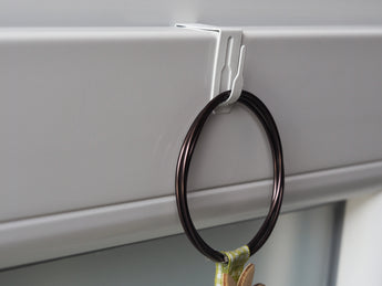 Schmaler Fensterhaken mit aufgehängter Fensterdekoration