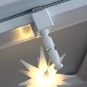 Weißer Fensterhaken mit Distanzhalter Größe M am Fenster mit leuchtendem Weihnachtsstern