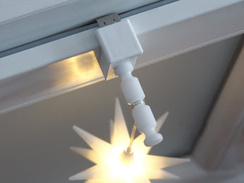 Weißer Fensterhaken mit Distanzhalter Größe M am Fenster mit leuchtendem Weihnachtsstern